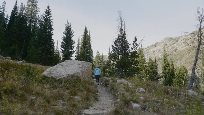 A woman is hiking on a trail