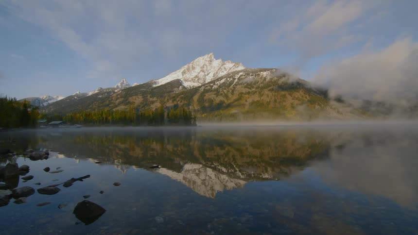 Reflection of a snow capped mountain on a lake in early morning
