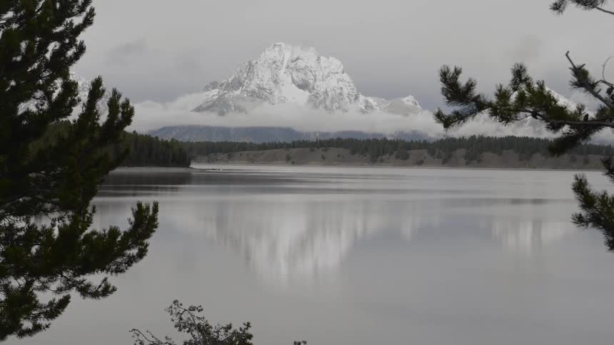 A large lake sits in front of a high snow covered mountain