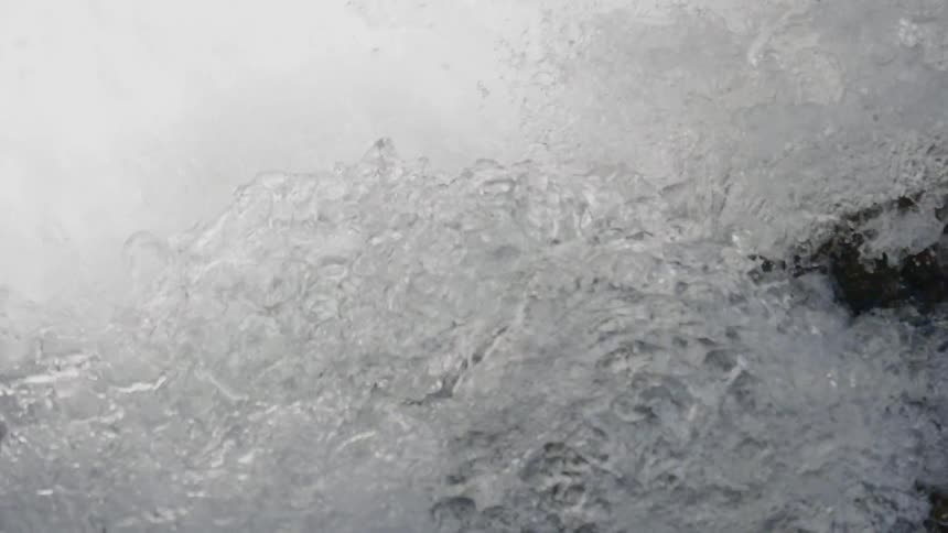 Water splashes and foams against the rocks