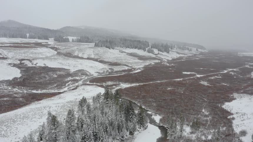 The fields are covered with snow and fog below