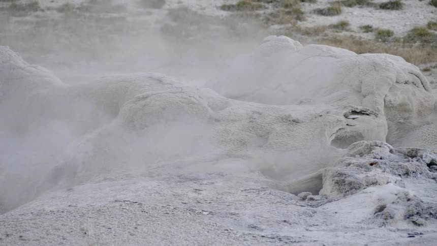Steam rises off of a muddy surface