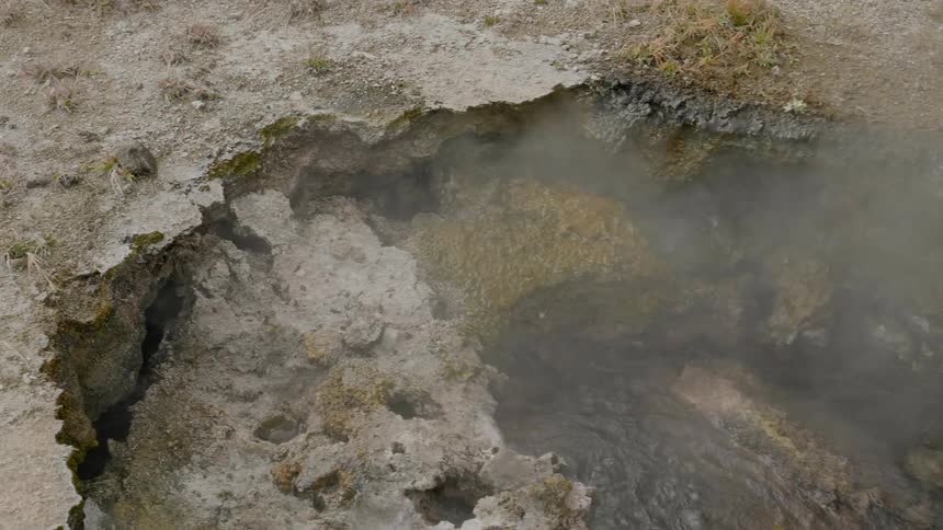 Steam releases from a rocky formation that holds water