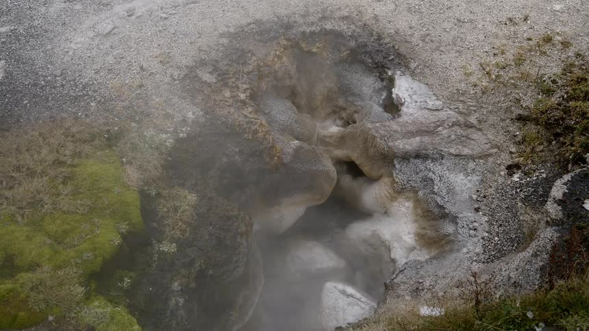The hole in the rocks has steaming water