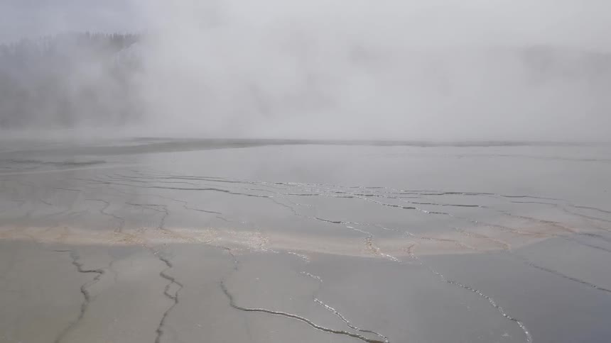 Steam rises off of a surface with cracks in it