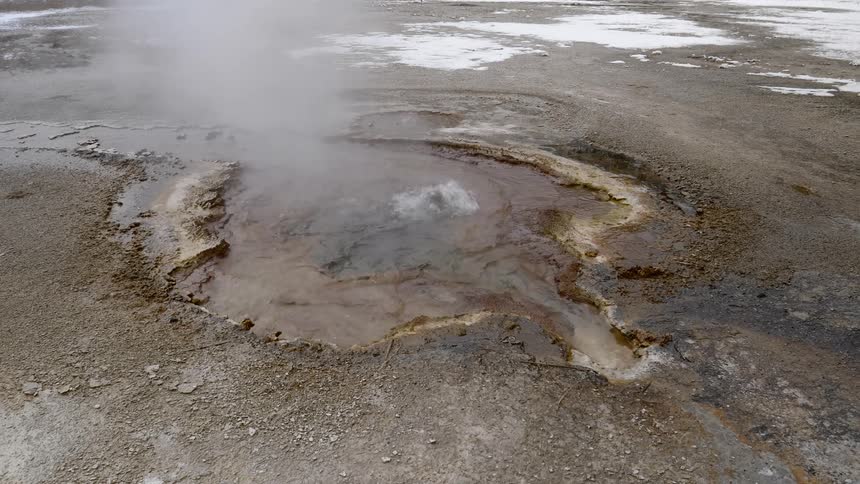 A natural hot spring on snowy terrain