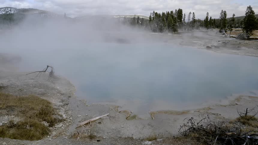 The steam rolls over the hot springs