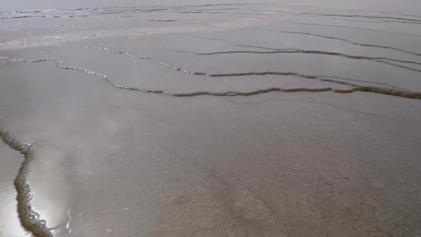 A vast stone surface covered in water