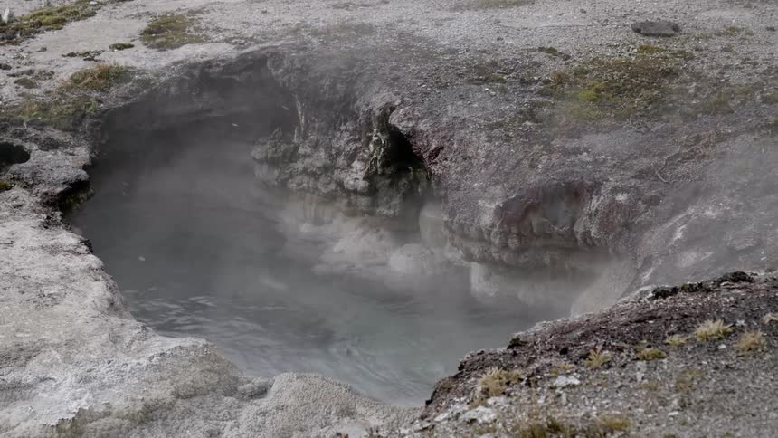 Steam rises up from a hot spring as it snows