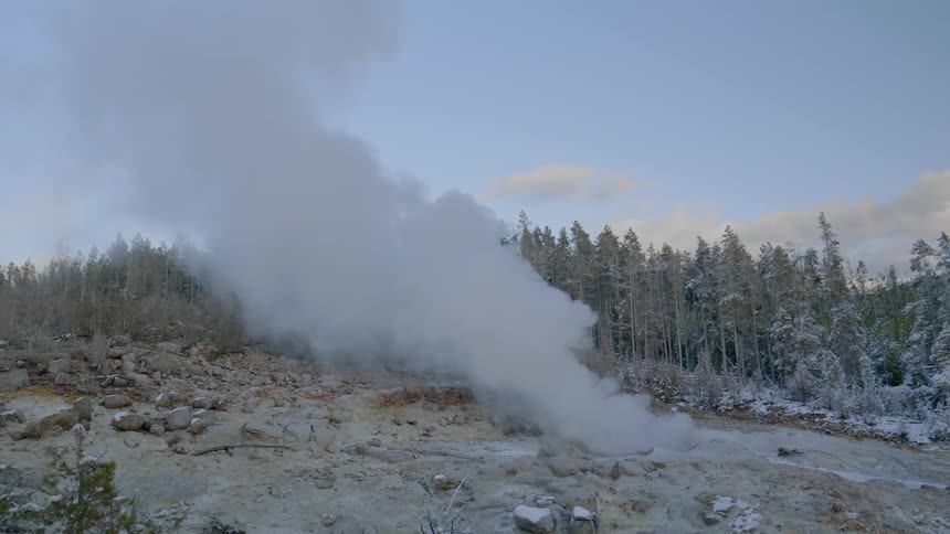 Smoke rises from the rocky land near the creek