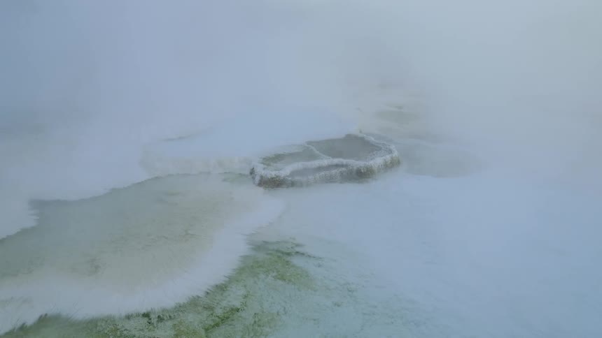 A hot spring with steam coming off of it
