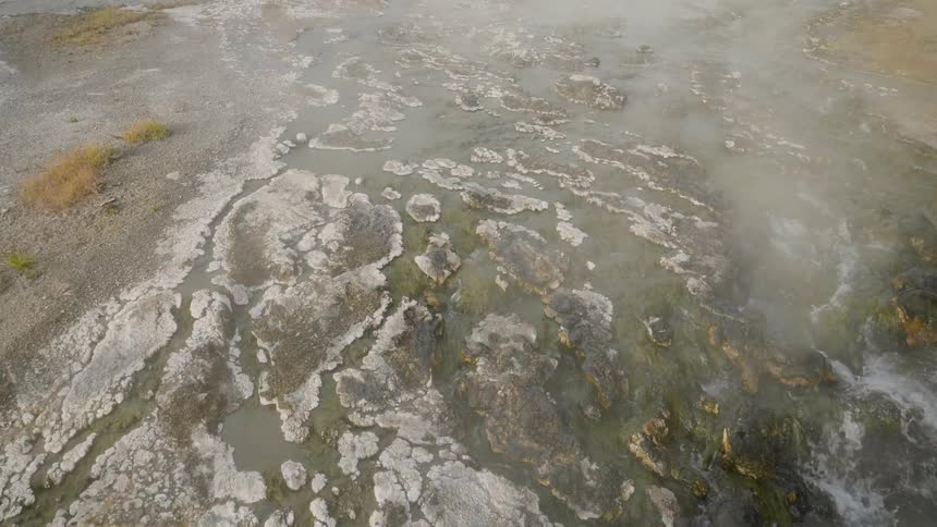 A steaming hot spring running down a rocky hill