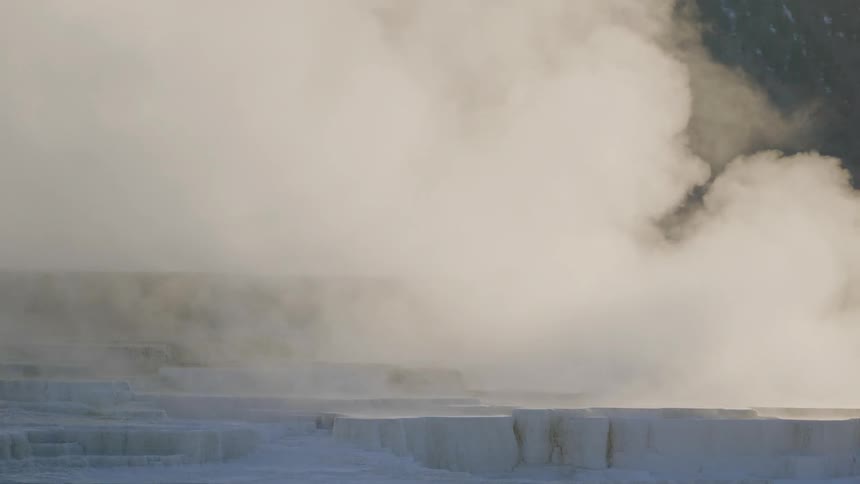 Huge clouds of steam rise off of a body of water