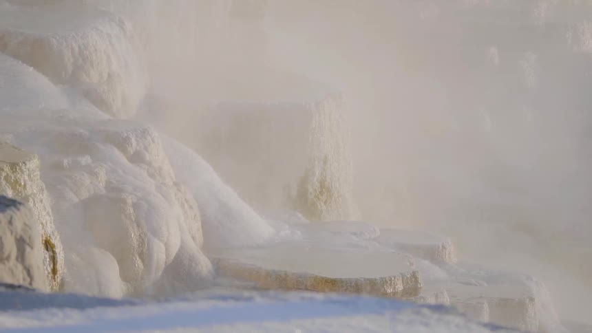 Snow melting waterfall rushing down a rocky slope