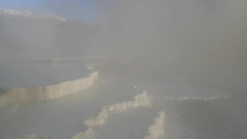Layers of ice on the water with snow blowing across