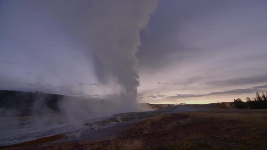Steam erupting from a geyser in the countryside