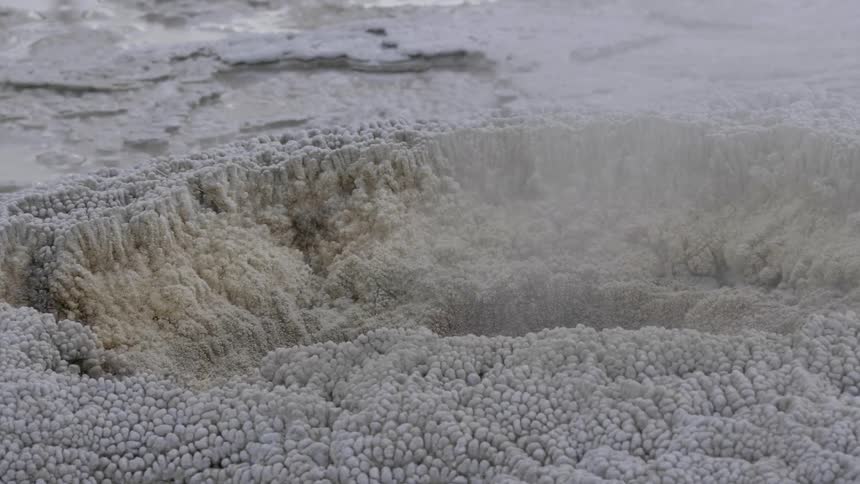 Steam rises from the snow covered ground