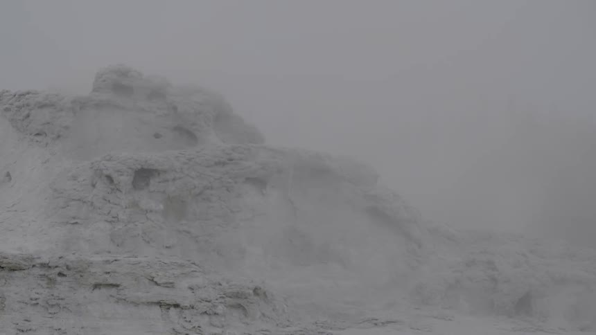 A snowy mountain is visible on a foggy day