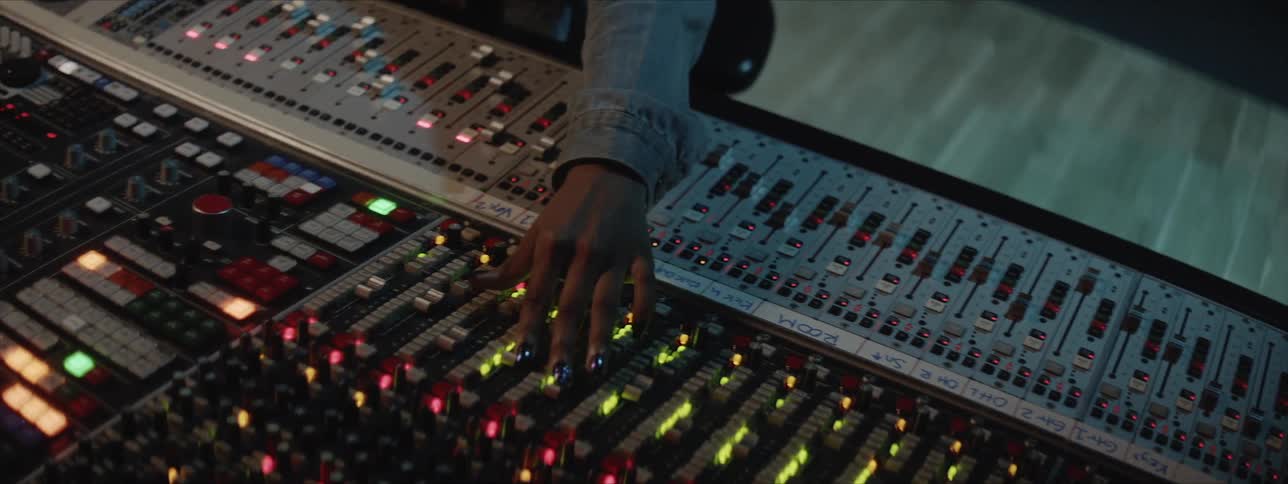 A woman pushes buttons on a sound board