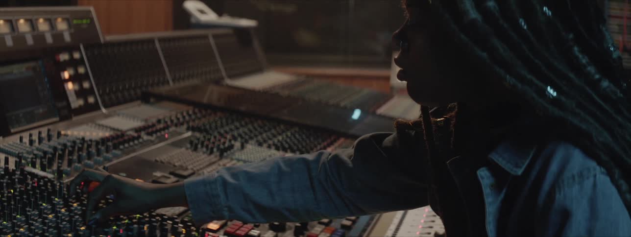 Female editing music on mixing console in a studio