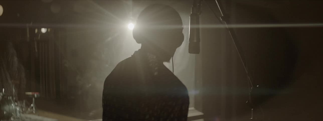 A silhouette of musician sing under the light