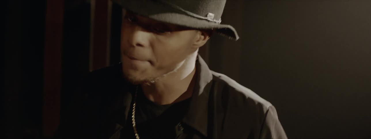 Ayoung black male wearing a black hat is using drumsticks to play a set of drums