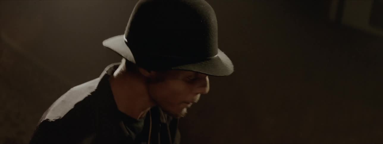 Black drummer wearing black hat plays drums at the stage