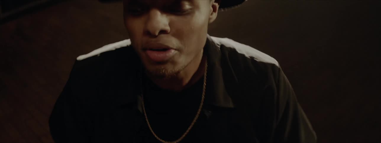 A man in a hat and collared shirt is drumming open handed