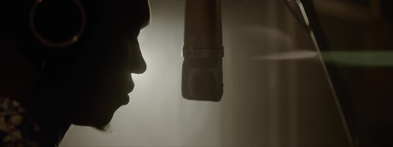 A man is dancing and singing into the microphone