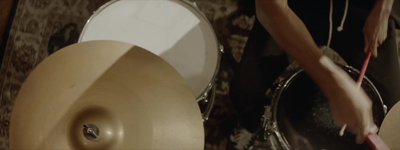 A drummer beats on the drums and cymbals