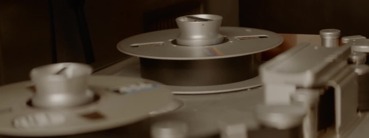 Two silver audio reels are spinning
