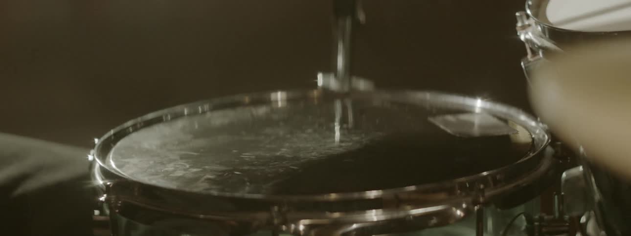 Black drummer plays drums at the stage
