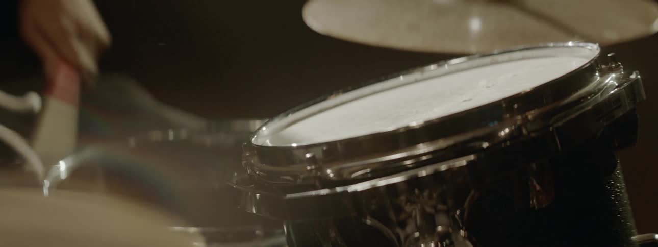Black drummer plays drums at the stage