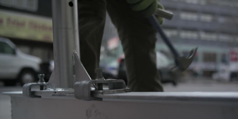 A man bangs a piece of metal into place with a hammer