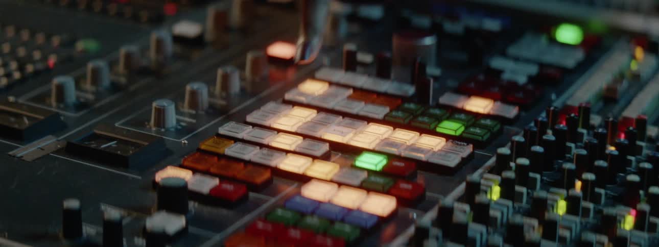 A black female with dark nail polish is pushing buttons on a music soundboard