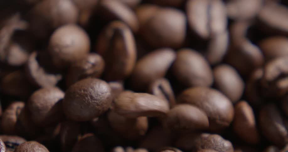 Coffee beans fall on black bowl