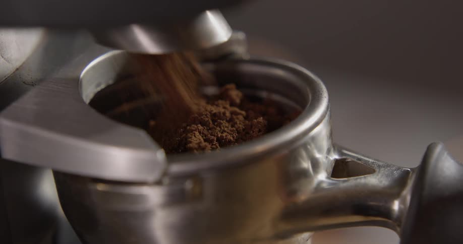 A portafilter is filled with ground espresso beans