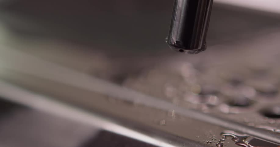 A nozzle blasts compressed water against a metal surface