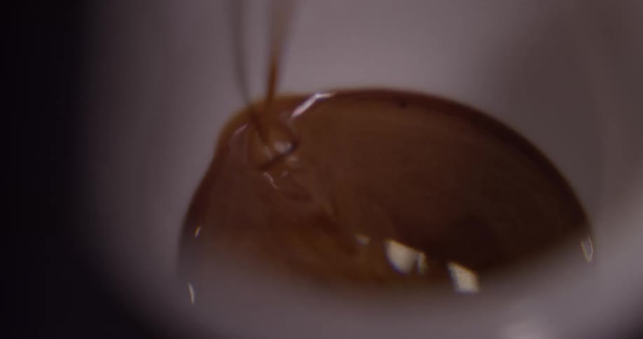 The coffee slowly fills the cup
