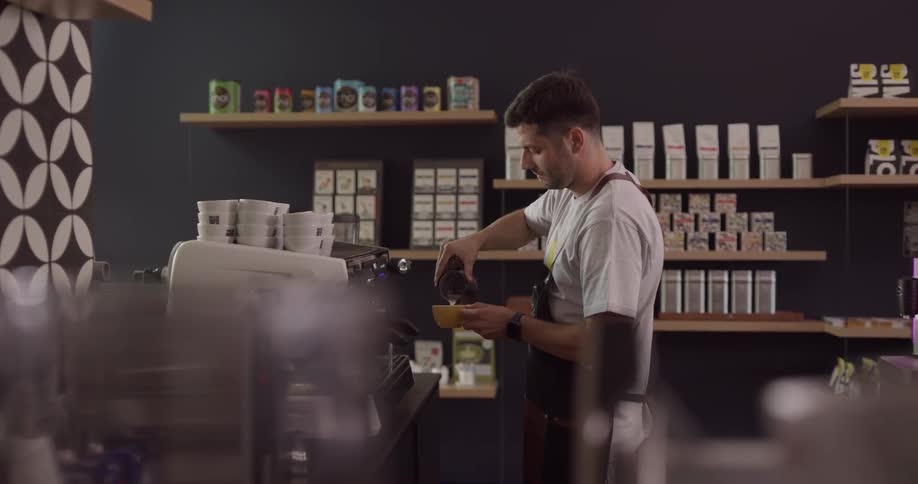 Male barista preparing a latte at a coffee shop