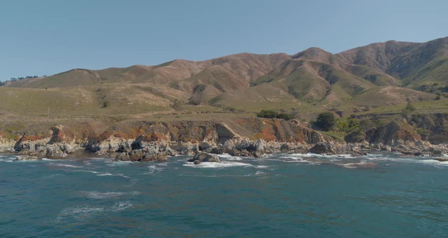 A rocky coast with hills in the background