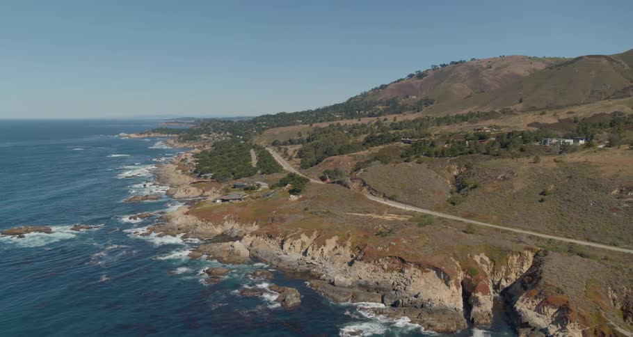 Aerial view of a coastal area with sparse housing and road