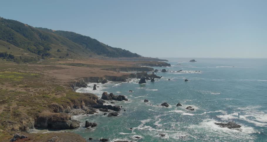 A rocky coast with hills and the sky in the background