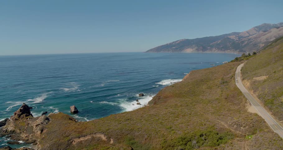 A road winds along a rocky coastline