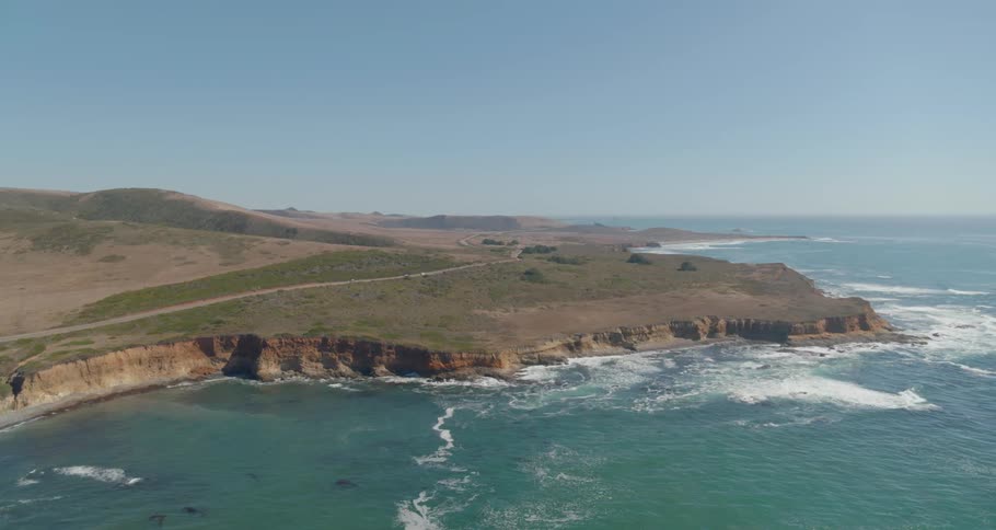 Waves crash along the high hill coast line