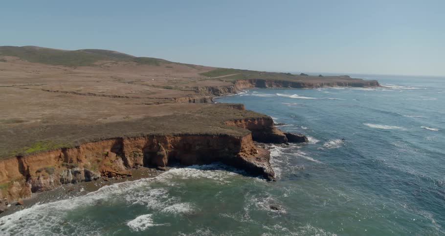 Waves crash upon the rocky cliffs of a shoreline