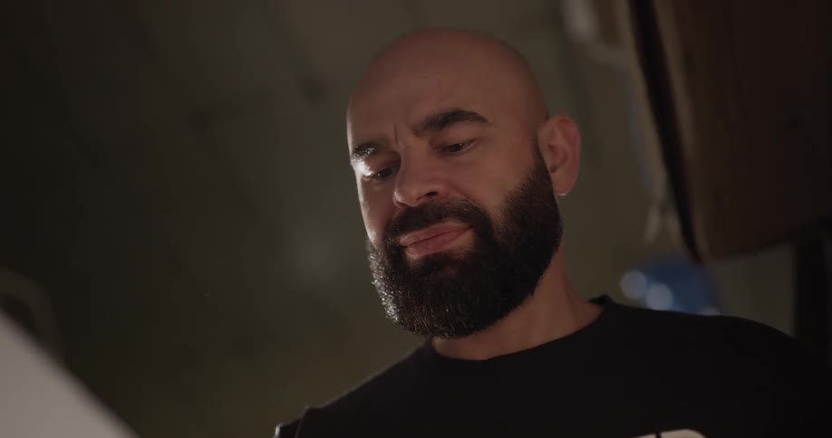 A bearded man is staring at his hand