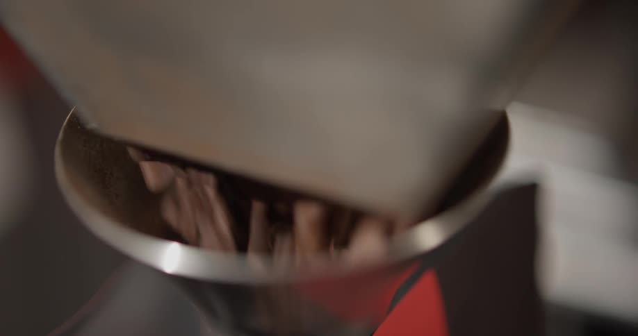 A bag is being filled with coffee beans from a machine