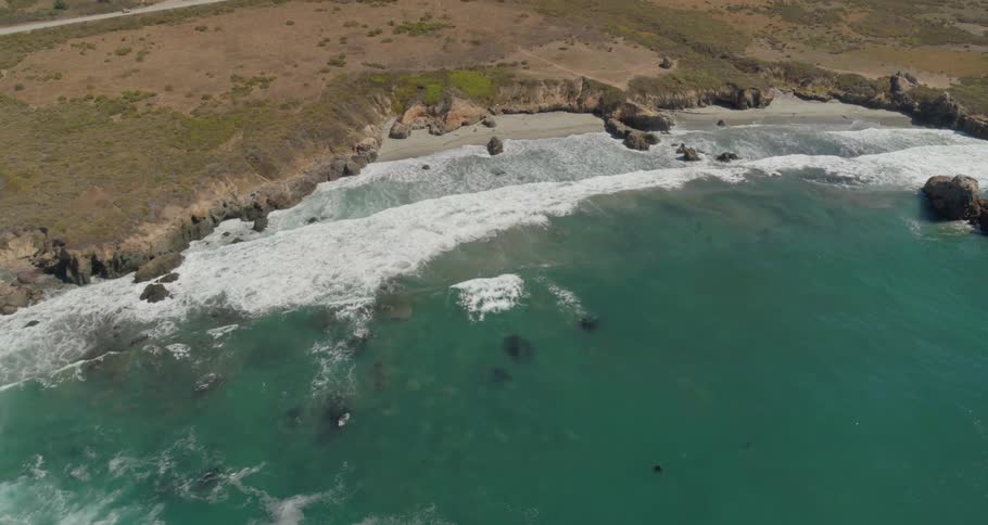 An aerial view of a body of water and a beach near land
