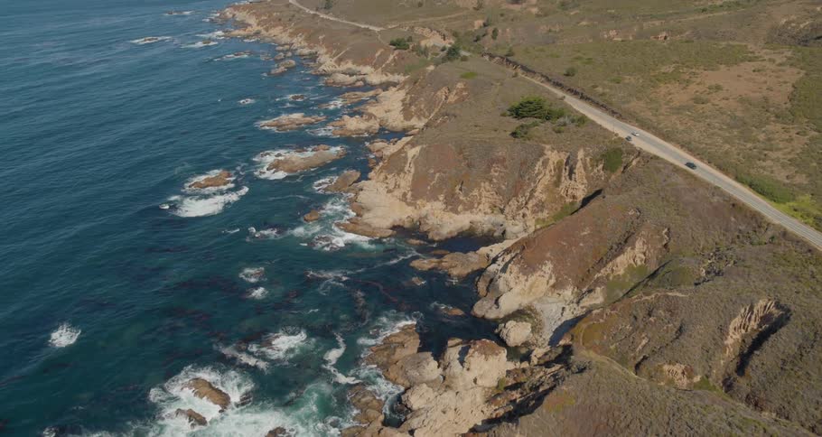Vehicles travel down the highway near the ocean